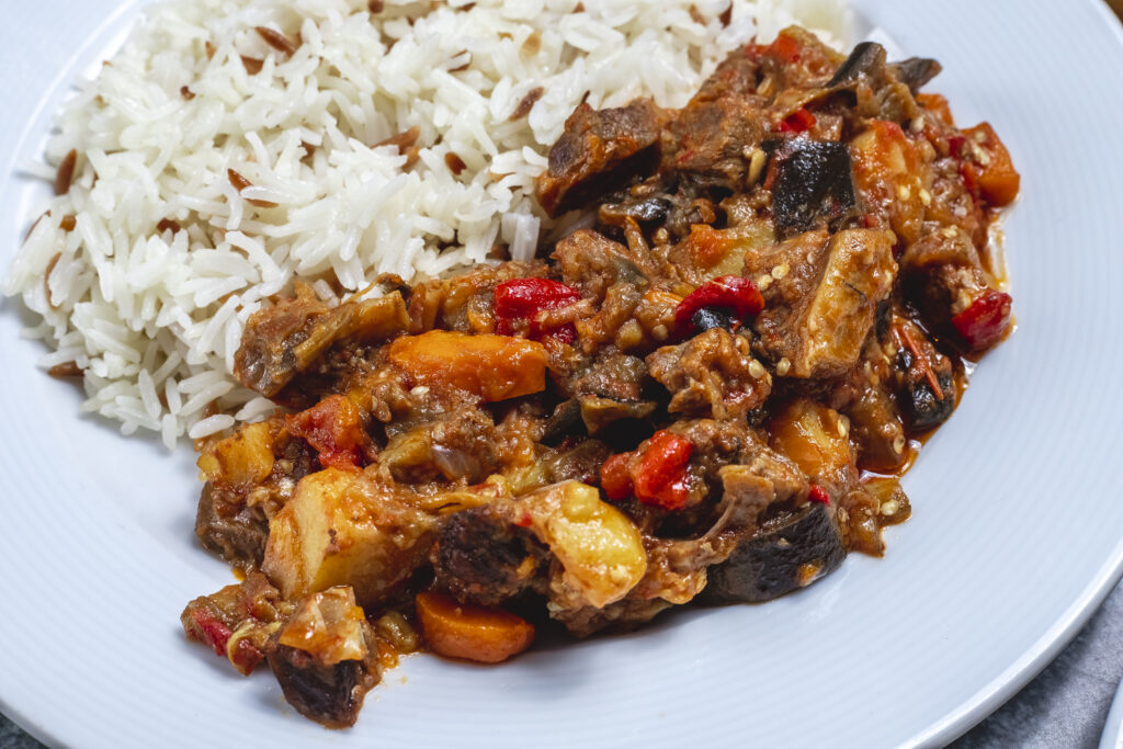side view meat stew lamb stew with fried onion dried fruits with rice plate